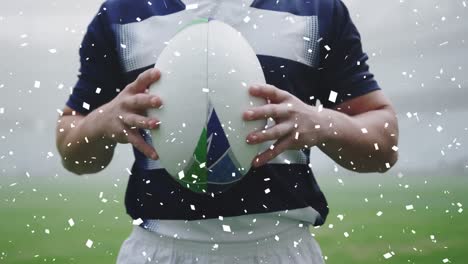 Animation-of-white-confetti-falling-over-mixed-race-male-rugby-player-holding-a-rugby-ball