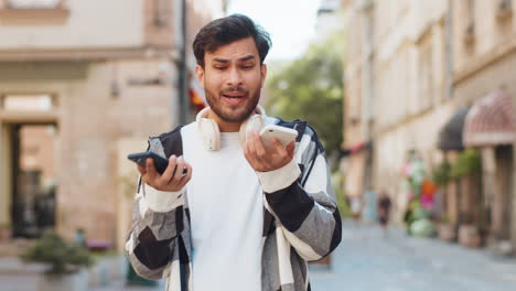 stressed indian man talking screaming on mobile phones having conflict quarrel complaint on street