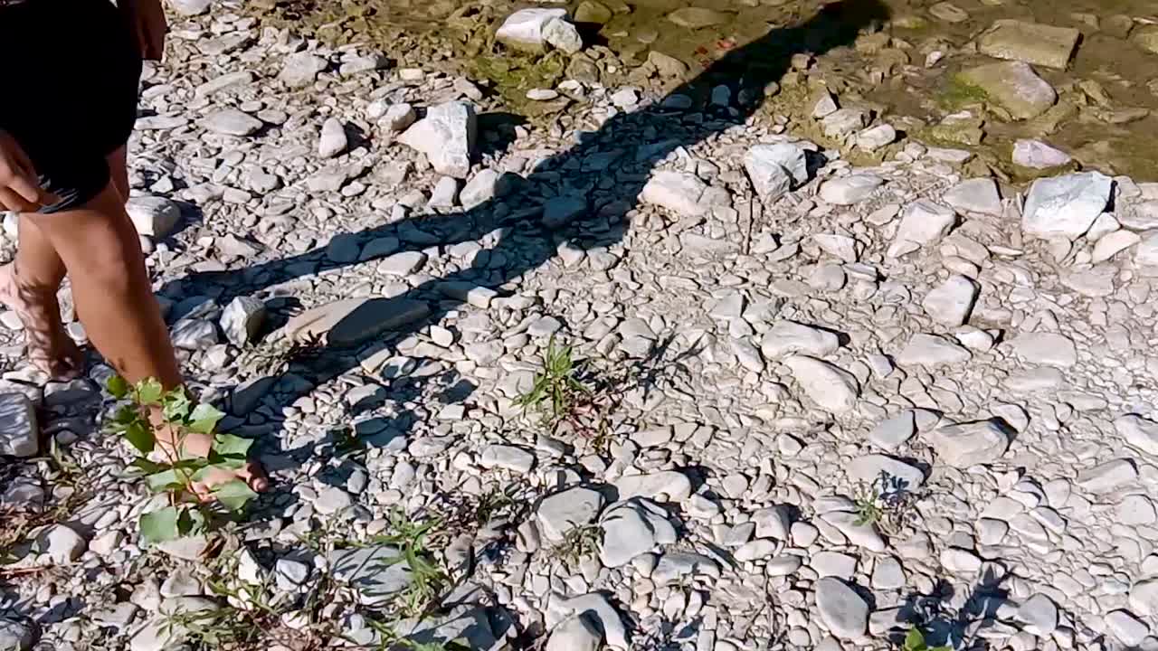 바위 가득 한 강변 을 따라 맨발 로 고 있는 아이