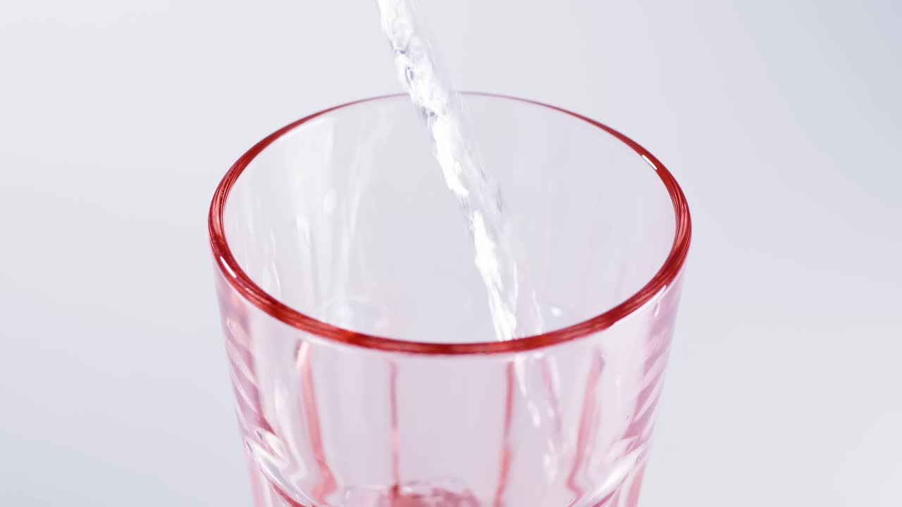 느린 동작으로 유리 근접 촬영에 순수한 물을 부었습니다.