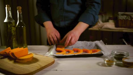 raw pumpkin pieces ready for baking. chef put pumpkin slices on baking tray