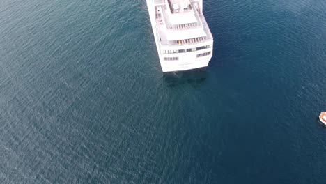 Aerial-shot-of-cruise-ship-heading-towards-tropical-island