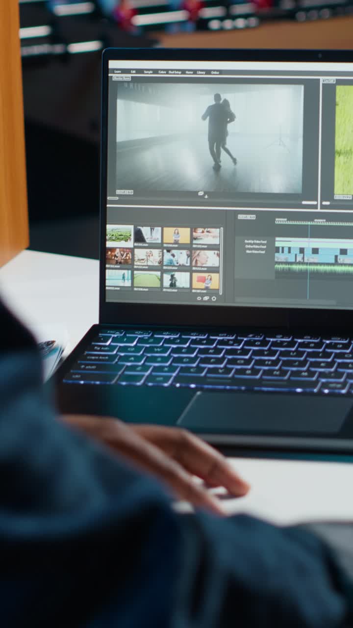 Video verticale: Videografo che assembla spezzoni di film su un laptop, modificandoli