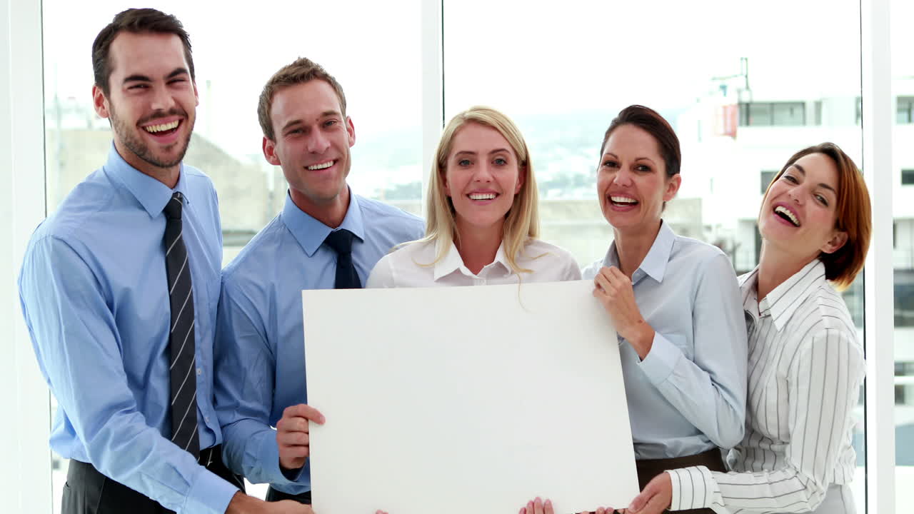 equipo de negocios feliz mostrando una tarjeta blanca