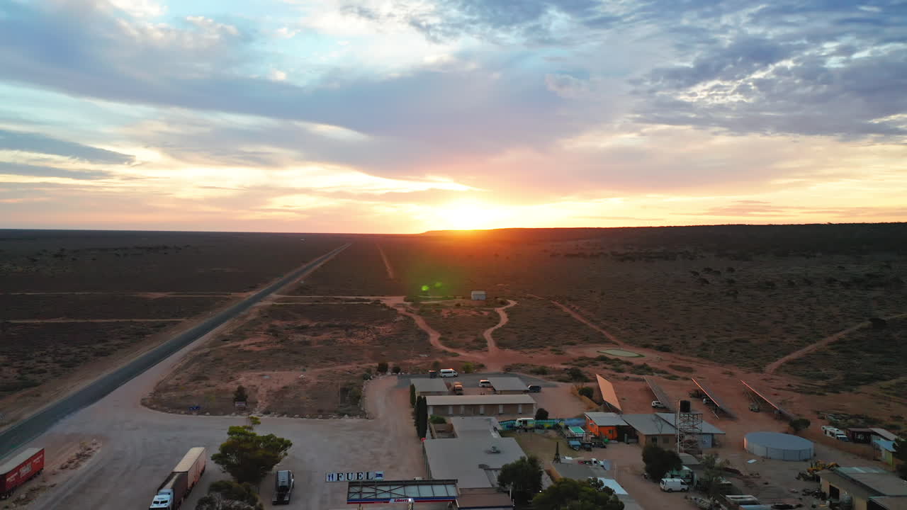 vista aérea sobre una gasolinera y una parada de camiones, en medio del desierto, en australia - tire hacia atrás, tiro de drones