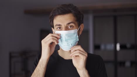 Dark-haired-man-in-front-camera-put-on-a-mask-indoors