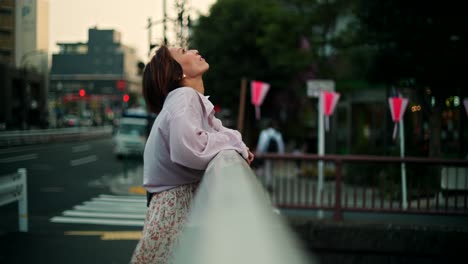 woman standing on bridge in urban japanese city