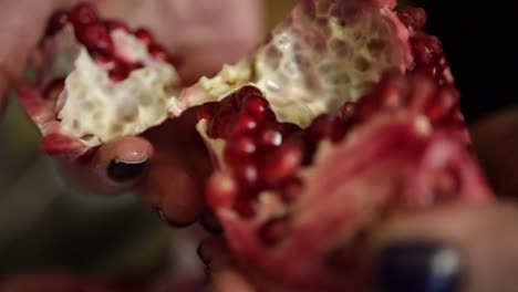 peeling pomegranate. opening and showing red seed