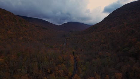 Hermosas-Imágenes-De-Drones-De-Una-Carretera-Que-Atraviesa-Un-Colorido-Valle-Montañoso-Otoñal