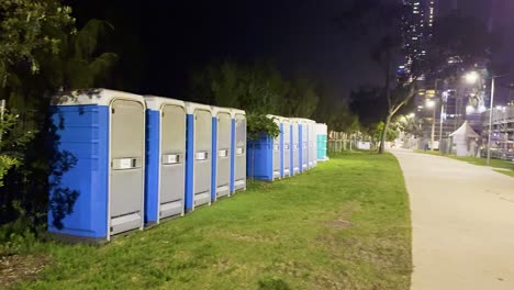 row of portable toilets under night lights