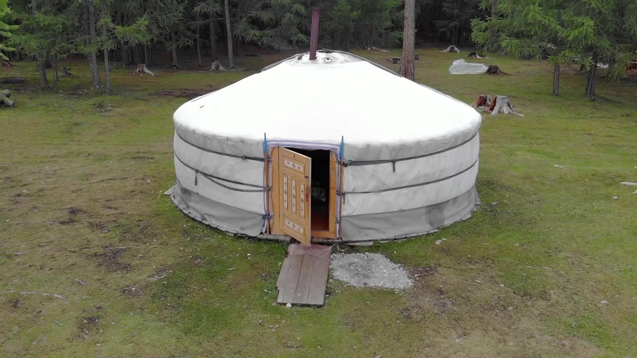 Luftfoto av en tradisjonell yurt i en lysning i skogen