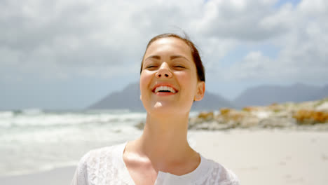 Front-view-of-young-caucasian-woman-standing-at-beach-on-a-sunny-day-4k-