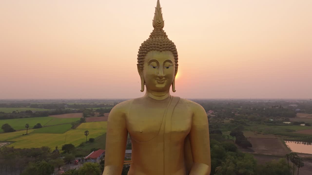 Ripresa con drone di una statua del Buddha dorata illuminata dal sole del mattino, Thailandia