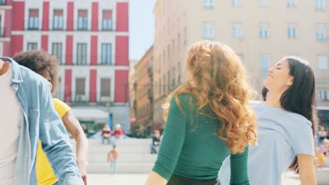 a diverse group of young friends dancing and having fun in an urban setting