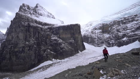 lonely female in front of glacier in cold mountain landscape