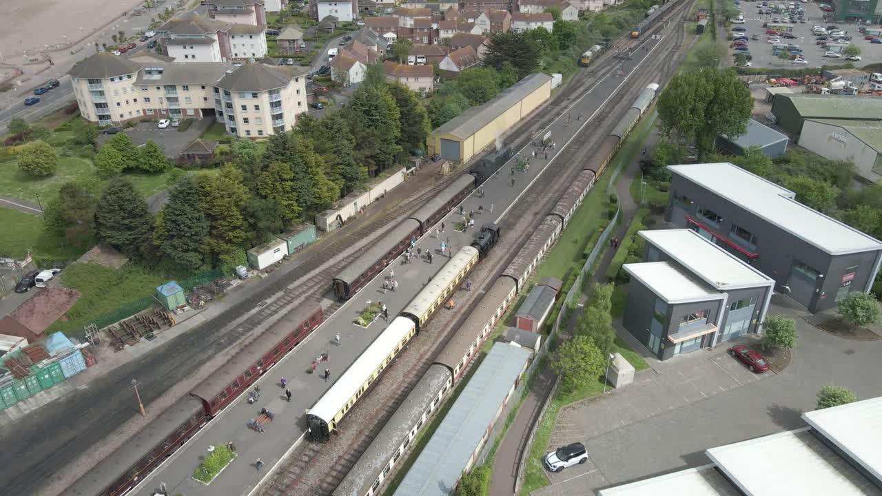 Aerial view of the Minehead steam railway station England's longest heritage line, running 20 miles between Minehead and Bishops Lydeard. Drone rotating to the right over one steam train parked