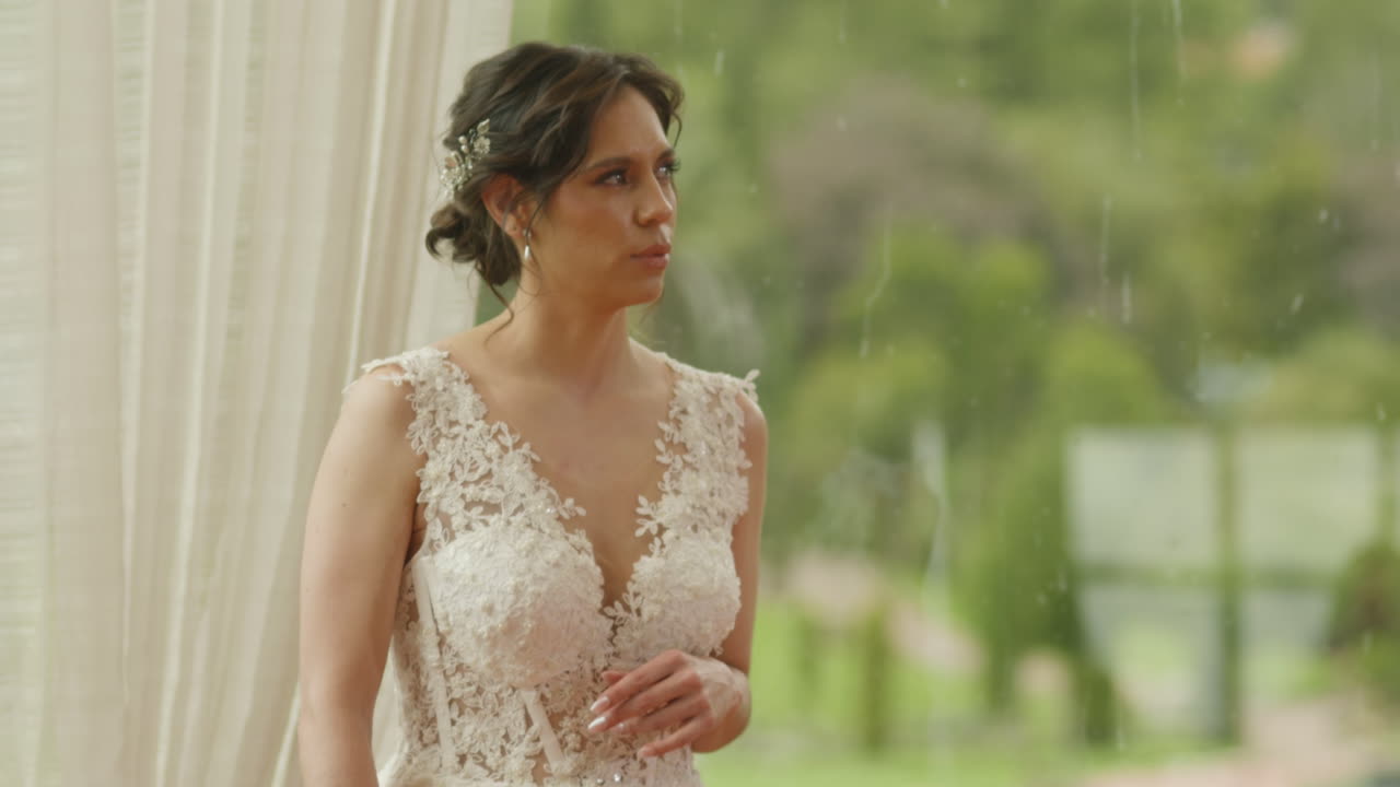 A bride with her back turned, wearing a white dress