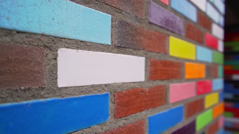 colourful decorative bricks laid in a red brick outside wall of a building