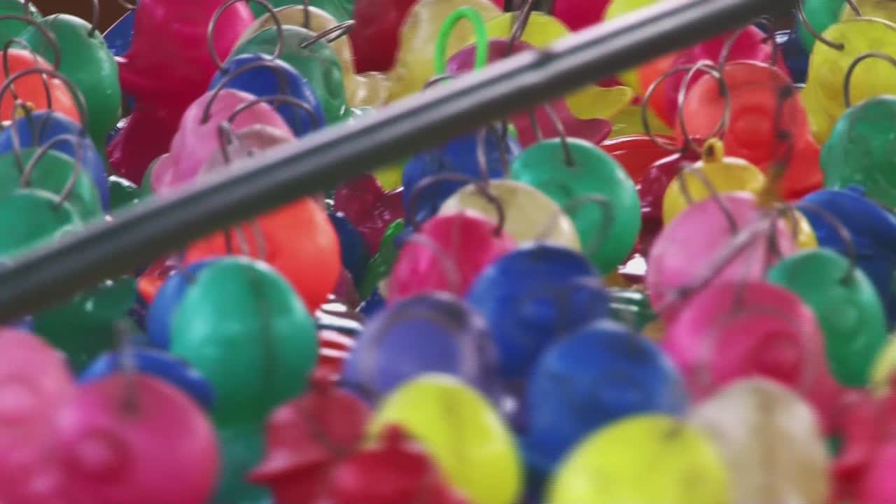 fotografía de cerca de un juego de pesca de pato de goma en un montón de diferentes colores en una feria