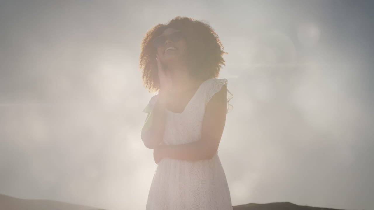 animación de una feliz mujer afroamericana en la playa sobre puntos de luz