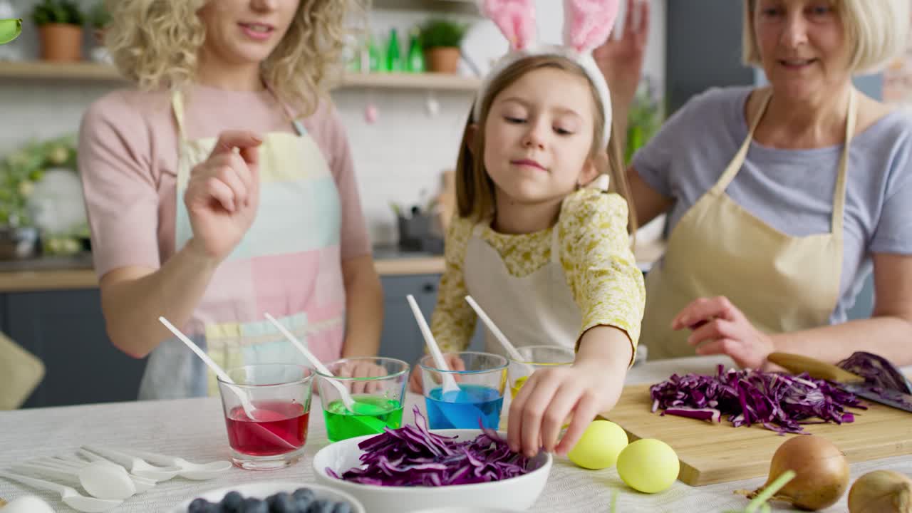 家族と一緒に自然な卵用染料を見せる女の子の映像