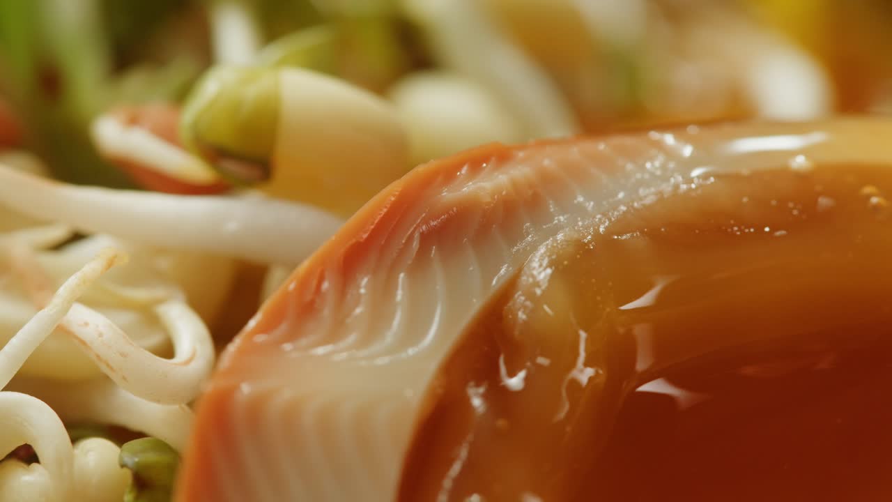 Close up of a bowl of egg noodle soup with bean sprouts