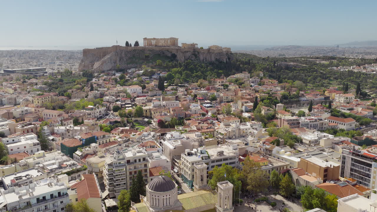 Vista aerea dell'Acropoli, con il Partenone che svetta sulla Cattedrale Metropolitana di Atene, e i quartieri all'ombra delle nuvole, Grecia.