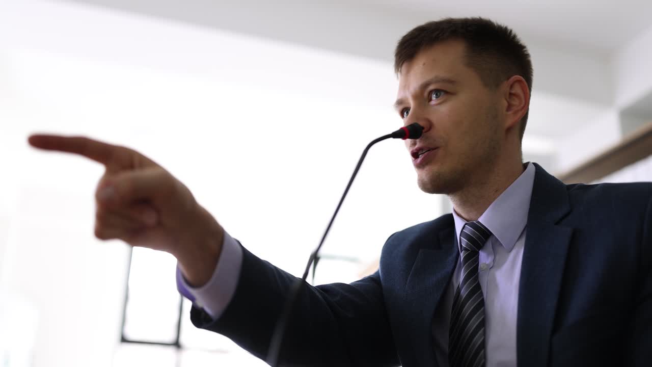 Uomo d'affari parla al microfono per amplificare il suono a una conferenza.