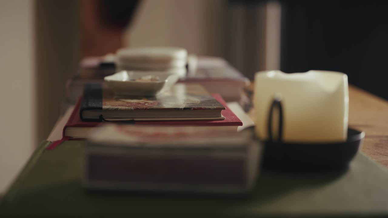 Hand sets phone on book, capturing calm indoor atmosphere