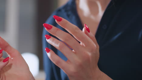 behavioral specialist clapping hands together while explaining concepts in therapy session, highlighting gestures and red manicured nails during intensely engaging supportive counseling interaction