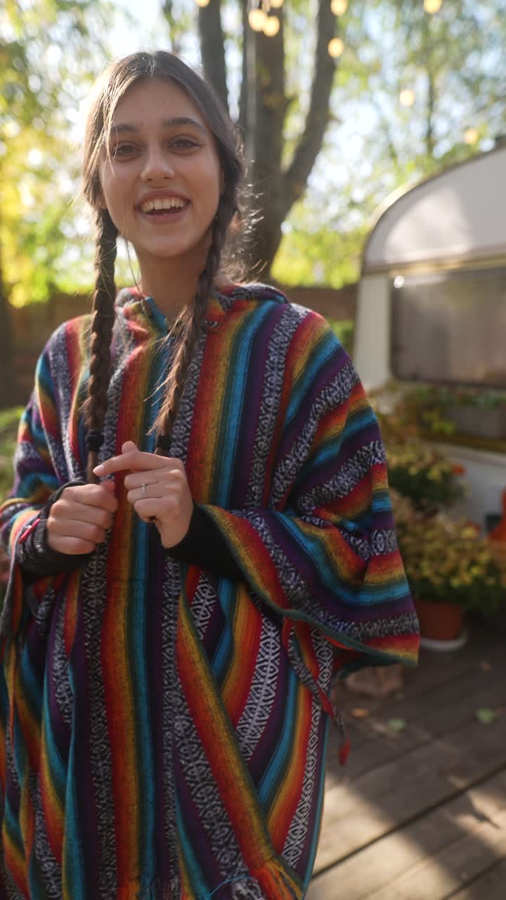 Kvinna klädd i en färgglad poncho utomhus
