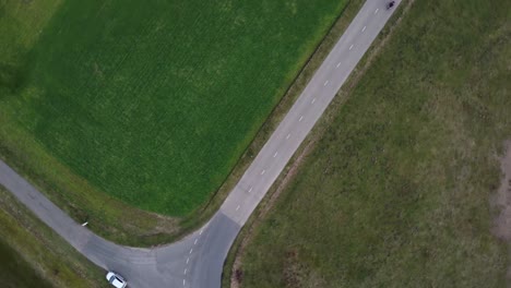 Aerial-drone-shot-slowly-turning-of-motorcyclist-driving-down-a-road