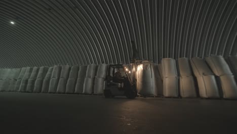 warehousing. forklift driver stacking big bag of raw material in warehouse. 
many bags of raw materials in the warehouse