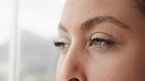 Close-up-of-thoughtful-biracial-woman-looking-through-window-at-home,-slow-motion