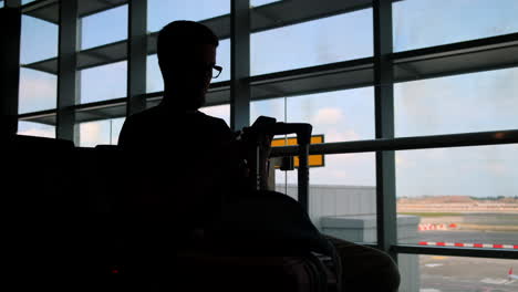 silhouette of a person using a smartphone at the airport