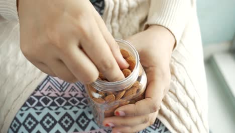 Woman Eating Almonds from Jar