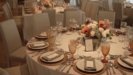 round wedding table with flowers and amber glasses at indoor reception location irrelevant