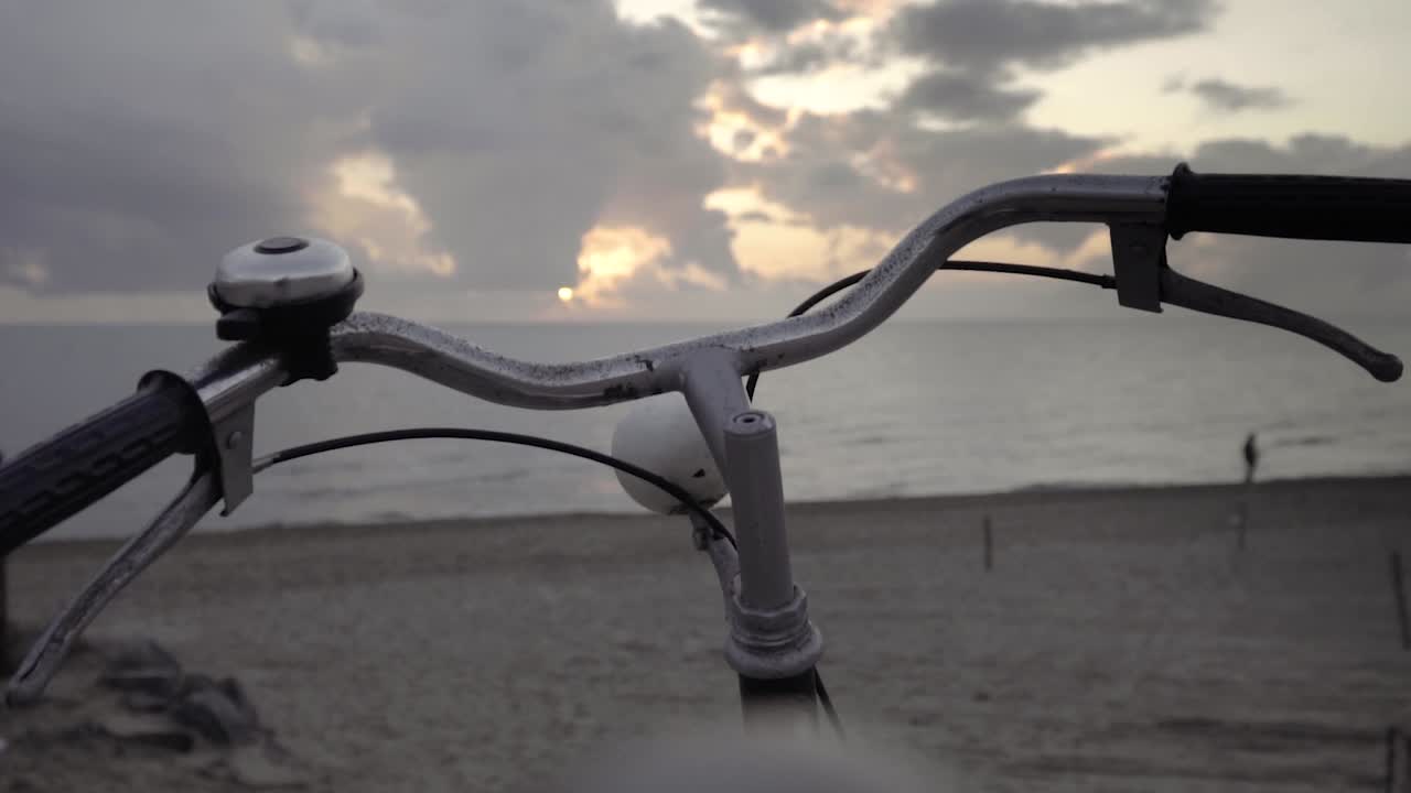 Vintage '80s touring bicycle by the sea and a man walking along the shore at sunset SLOW MOTION 120 FPS - Golden hour