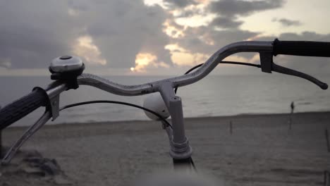 vintage '80s touring bicycle by the sea and a man walking along the shore at sunset slow motion 120 fps - golden hour