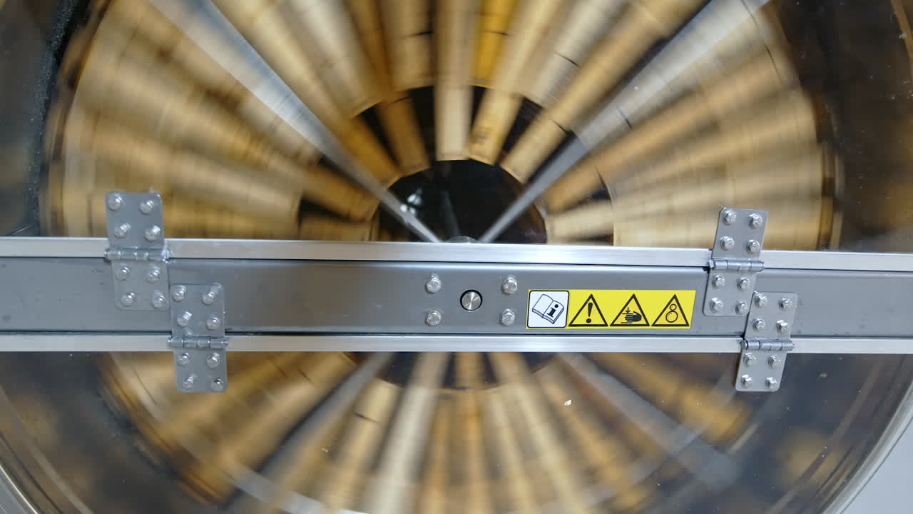 Spinning of honey extractor. Removal of honey from the honeycomb in special device. Centrifuge machine is pumping organic honey while spinning with frames with honeycombs. Top view.