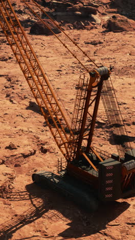 a large orange crane sitting on a dirt construction site