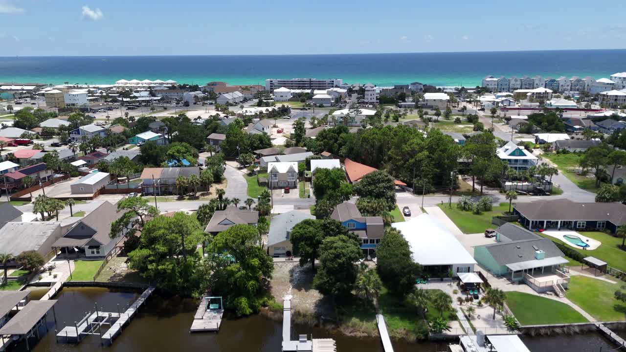 Forward drone movement over the peaceful waterfront neighborhood with boats and private homes around local marinas, Panama City Beach, Florida, USA