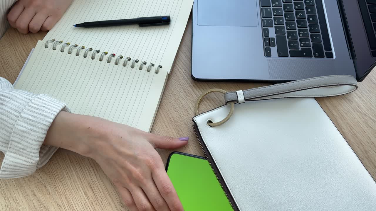 Woman takes out telephone with green screen from her handbag.