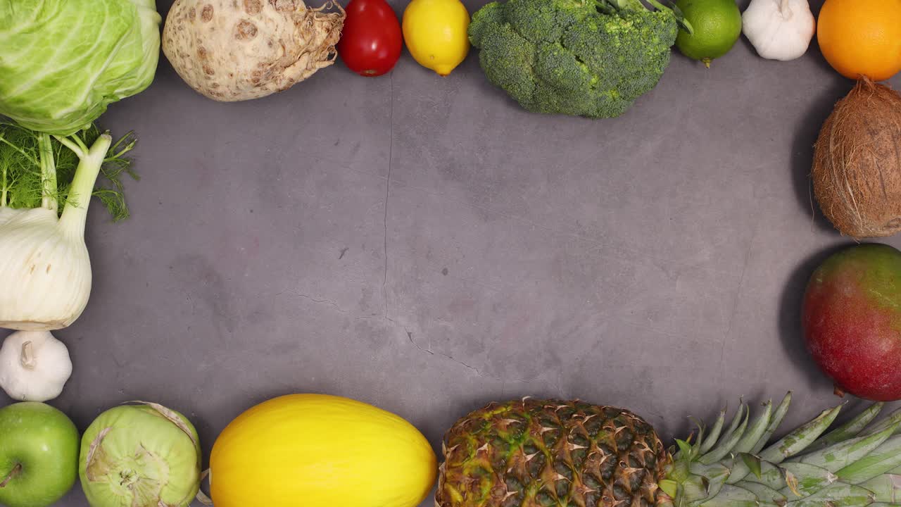 frutas y verduras frescas ordenando y haciendo el marco para el texto en fondo oscuro. detener el movimiento