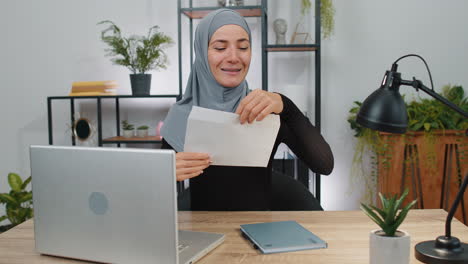 Carta-De-Mujer-Musulmana-Con-Sobre-Abierto-Para-Sentirse-Feliz,-Promoción-De-Crecimiento-Profesional,-Aprobación-De-Préstamo-Bancario