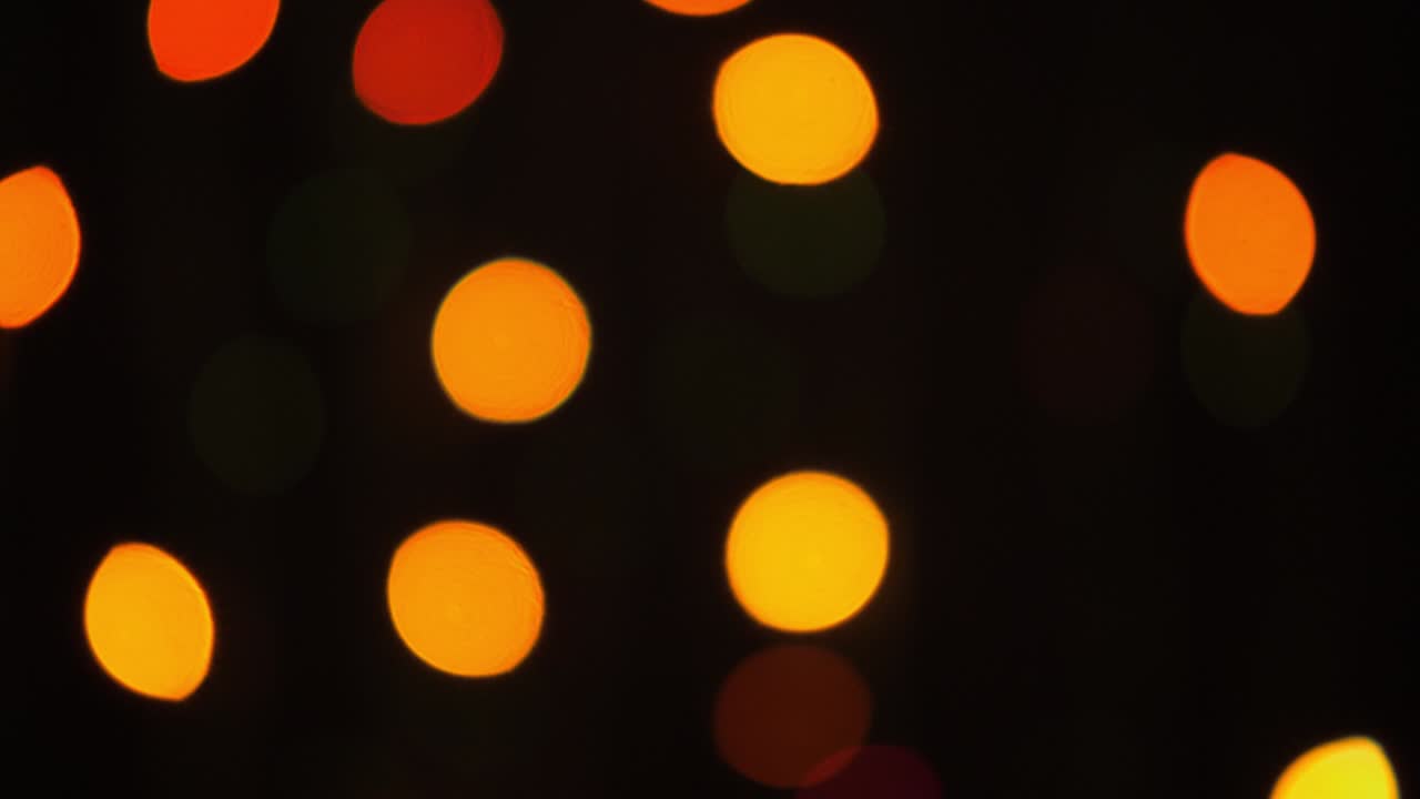 Scatto bokeh di luci sfocate e sfuocate dell'albero di Natale che lampeggiano su sfondo nero