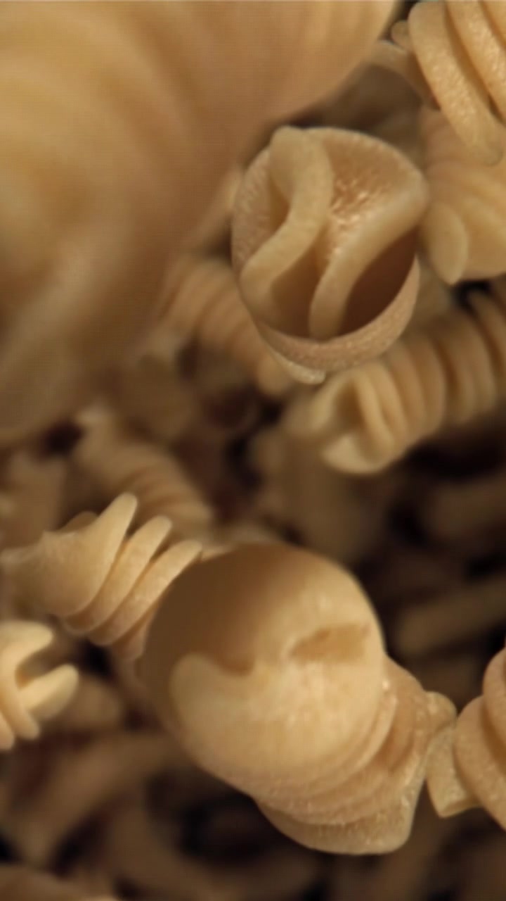 Pasta fusilli cruda che cade al rallentatore