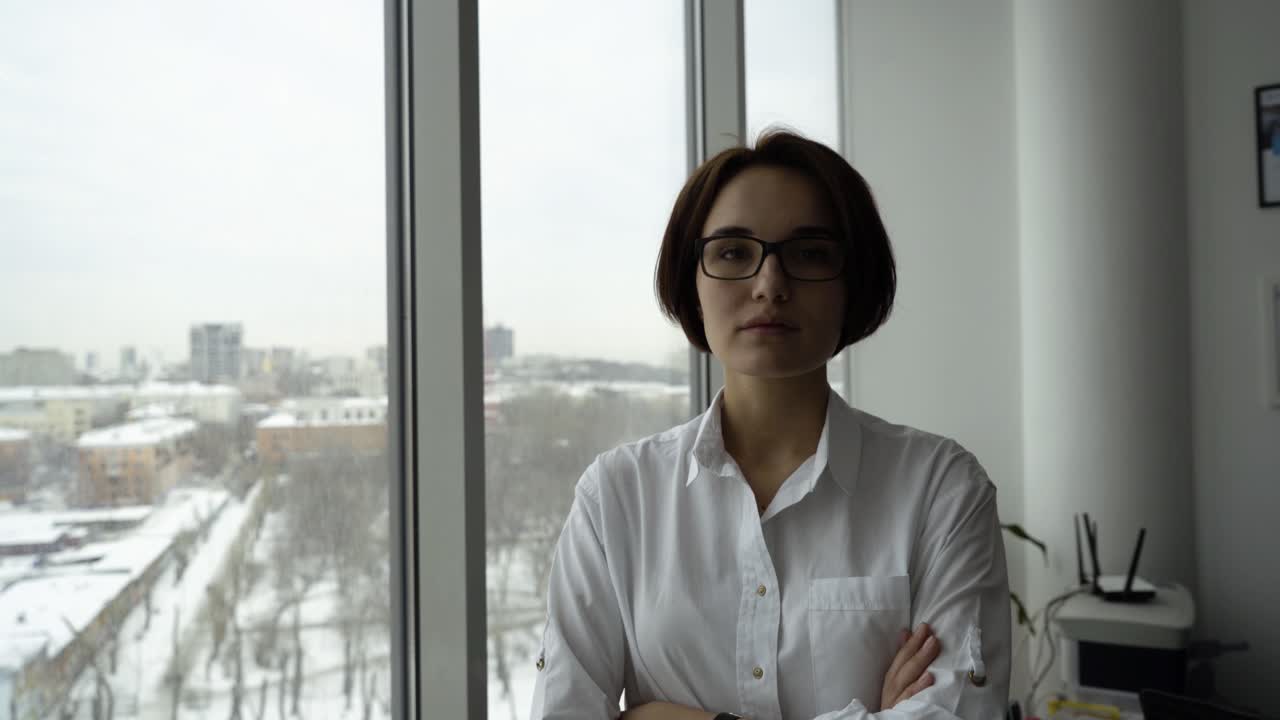 mujer en la oficina con vista a la ciudad