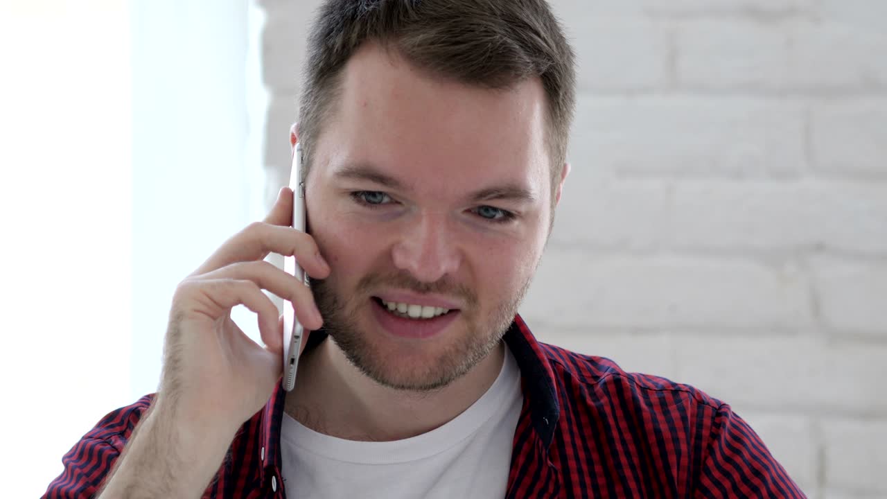 로프트 직장에서 전화로 대화하는 젊은 남자