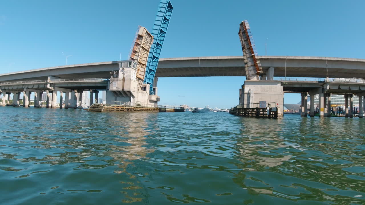 마이애미 에서 왼쪽 으로 지나가는 견인 보트 와 함께 다리 하부 통로 에 접근 하는 작은 보트 에서의 전망